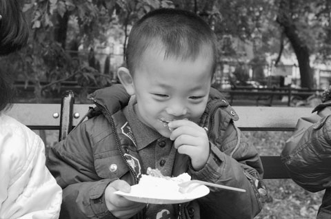 Little Chinese kid eating boiling rice