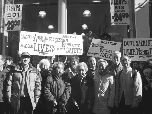 Black and white image of a group of people holding protest signs in front of a store.