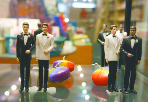 Several male figurines in tuxedos are displayed, with colorful decorative gourds nearby.