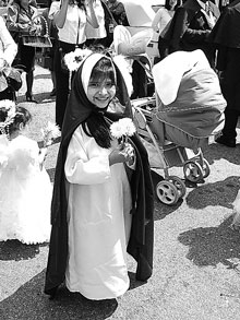 Girl in costume holding flowers.