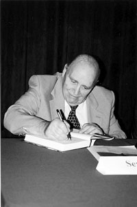 Former police Commander Seymour Pine signing David Carter's definitive book on the Stonewall Riots. (Photo by Lincoln Anderson)