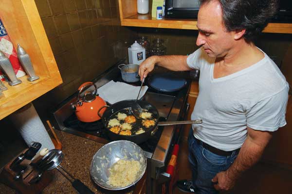 The latkes debate — to shred or grate? 1 The author’s friend, Barrett Zinn Gross, making an early batch of Hanukkah latkes with shredded potatoes. Downtown Express photo by Tequila Minsky