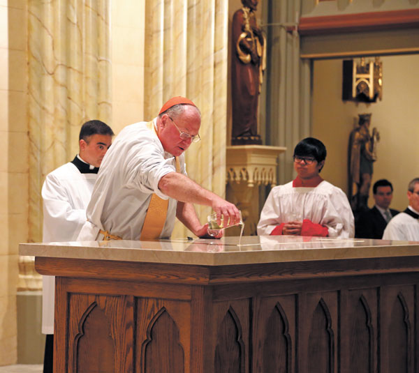 Dolan anointed the reopened Church’s altar with “chrism,” or consecrated oil.  Photo by Jefferson Siegel