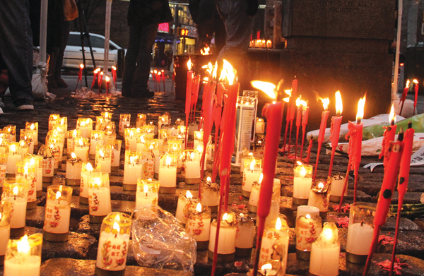 Candles burned in Kimlau Square Saturday evening at a memorial for Police Officers Rafael Ramos and Wenjian Liu.  Photo by Tequila Minsky