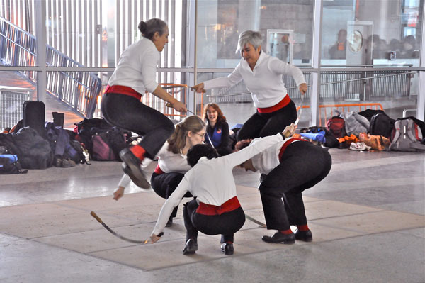 At the Whitehall Street Staten Island Ferry Terminal, members of Half Moon Sword leap over flexible metal swords, in a flashy display of English-style rapper sword dancing.