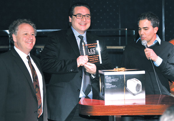 The hard work of Mark Miller, president of the Lower East Side BID for the past four years, center, was recognized, as he received an iPad, presented by Bob Zuckerman, the BID’s executive director, left, and Michael Forrest, the BID’s vice president, right. The iPad was jokingly hidden inside a toaster box.  Photo by Sam Spokony 