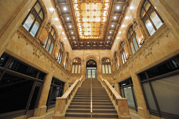 Downtown Express photos by Terese Loeb Kreuzer The lobby of the Woolworth building at 233 Broadway. The stairs once led to the Irving Bank, which occupied several floors of the building when it opened in April 1913.  Corbels in the lobby of the Woolworth building depict the men who played a role in creating it. Architect Cass Gilbert is shown holding a model of the building, near right, and Frank Woolworth, who hired him.