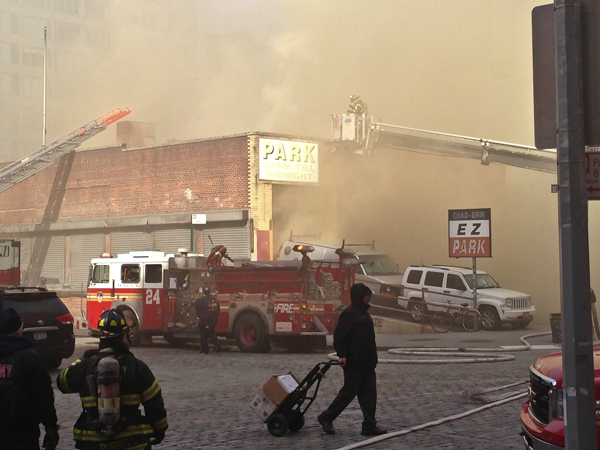 Fire broke out at 10 a.m., spewing smoke into Greenwich St. as those with cars in the garage looked on.   Downtown Express photo by Tequila Minksy
