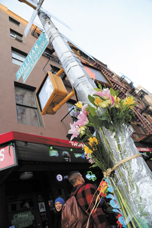 Flowers were left on two lampposts at Bleecker and Sullivan Sts. bearing honorary street signs for the officers.