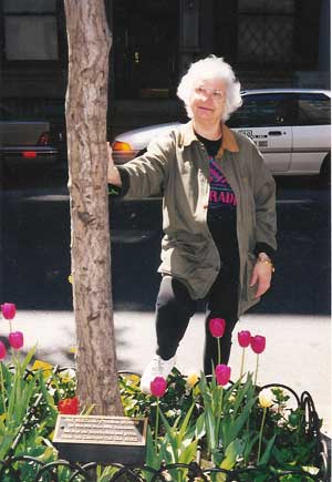 Patricia Buzzuro standing by the tree-pit plaque honoring her commitment to the Far W. 10th St. Block Association, of which she was the founder and longtime president. 