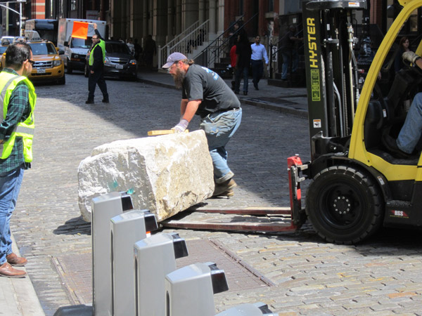 Photo by Lincoln Anderson Workers installed a large hunk of rock on Mercer St. north of Spring St. Tuesday morning to protect the new bike-share station recently sited there from oncoming car traffic.