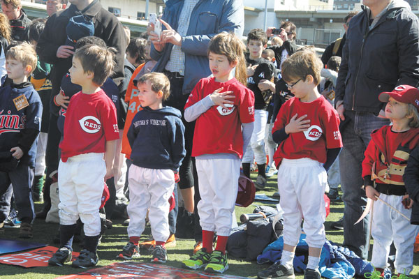 Photos by Tequila Minsky Bearing team banners and giant baseballs and waving pennants, Little Leaguers marched from the Christopher St. Pier to Pier 40 on Saturday morning for Greenwich Village Little League’s opening day. Above left, Sophia Spero sang the national anthem as the young baseball players patriotically doffed their caps and put their hands over their hearts. Below right, Tobi Bergman, the leader of the Pier 40 Champions coalition of local youth leagues, praised the pier’s “beautiful fields,” but said they won’t be there forever “unless changes are made and something is done to bring in more money.” 