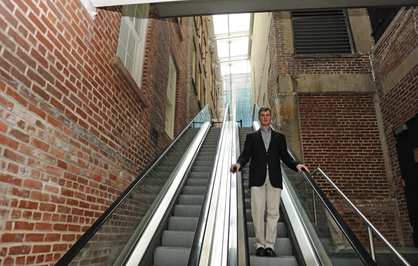 Jerry Gallagher, general manager of the South Street Seaport Museum, standing on the escalator that was damaged by Superstorm Sandy. On one side of him are the 12 Fulton St. galleries. On his other side is the museum's John St. building where the museum's offices and collection storage are housed. Downtown Express photo by Terese Loeb Kreuzer.
