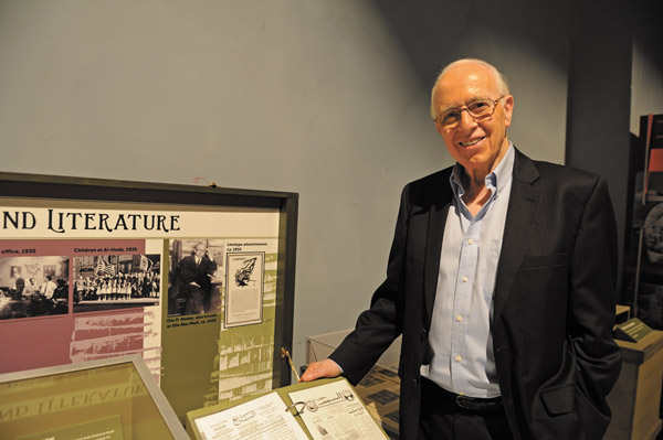Downtown Express photo by Terese Loeb Kreuzer Dr. Robert Madey, 80, a retired physicist, standing next to a photograph of his father, the renowned poet and journalist, Elia Abu Madi, at an exhibit about “Little Syria,” the former Lower Manhattan neighborhood, which stretched up Washington St. 