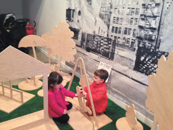 Photo by Maeve Gately They can’t wait for a playground: Two tots make good use of the interactive display, at Friends of 20 Street Park’s April 30 “Picture Your Park” event.