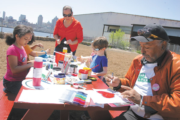 Downtown Express photos by Sam Spokony Luther Stubblefield, a longtime member of the Baruch Houses Tenants Association, right, drew pictures with children for an interactive installation by art designer Chat Travieso, one of the Paths to Pier 42 participants.