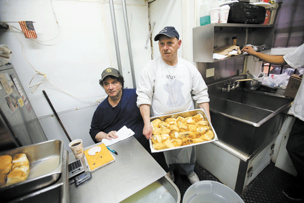 Photo by Jefferson Siegel Brothers Vincent, left, and Anthony Campanelli making “smokes” — balls of smoked mozzarella — on Saturday, the last day of retail business for Joe’s Dairy on Sullivan St.