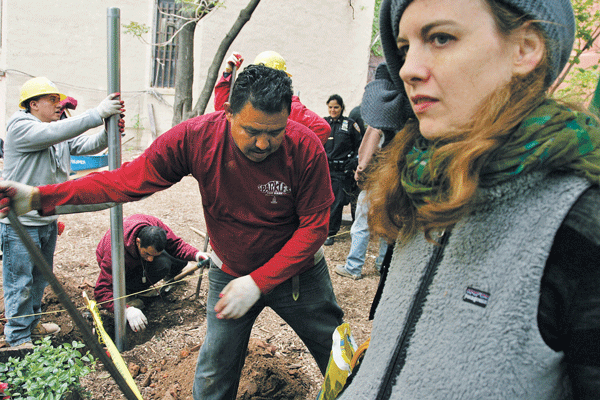 Photo by Sam Spokony Kate Temple-West, one of the directors of the Children's Magical Garden, at right, watched in dismay as workers fenced off the land owned by Hoyda.