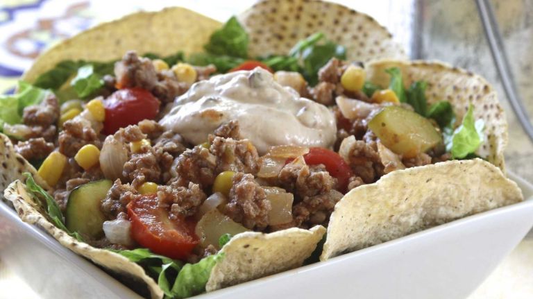 <b>WHAT YOU'LL NEED</b>:<br><br> <i>Dressing</i>:<br> 1/2 cup reduced fat sour cream<br> 1 tablespoon minced canned chipotle in adobo sauce<br> 1 teaspoon lime juice<br><br> <i>Salad</i>:<br> 1 tablespoon canola oil<br> 1 1/2 cups chopped onion<br> 1 1/4 pounds lean ground turkey<br> 1/2 teaspoon ground cumin<br> 1/2 teaspoon salt<br> 1 medium (8 ounce) zucchini, cut into 1/2-inch pieces (about 2 cups)<br> 1 cup frozen corn, thawed<br> 1 cup cherry tomatoes, halved<br> 1 1/2 cups salsa<br> 6 cups shredded romaine lettuce<br> 2 ounces baked tortilla chips<br><br> <b>HOW TO:</b><br><br> 1. Combine the sour cream, chipotle and lime juice.<br><br> 2. Heat oil in large, nonstick skillet over medium high; add onion and cook, stirring occasionally, until softened, 3 to 4 minutes. Add the turkey, cumin and salt; cook, breaking the turkey into crumbles, until it is no longer pink, 6 to 7 minutes. Add the zucchini, corn, tomatoes and salsa; cook, stirring occasionally, until zucchini is crisp-tender, another 6 to 7 minutes. Remove from heat.<br><br> 3. To serve, make a bed of lettuce, top with turkey mixture and add dollop of dressing. Accompany with the chips. Makes 4 servings.