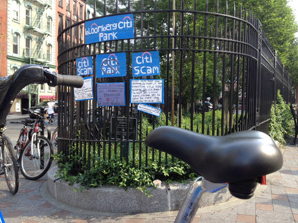 Bikes and protest signs outside Petrosino Square. 