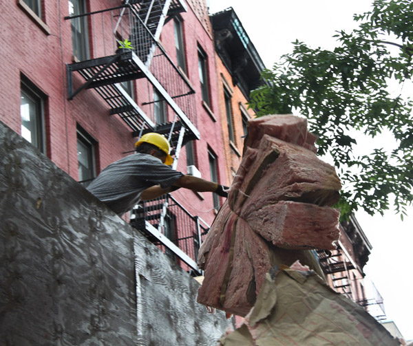 Photos by Tequila Minsky Workers removed material from the illegal seventh-floor penthouse at 514-516 E. Sixth St. on Wednesday. The B.S.A. ruled last fall that the penthouse must come down.