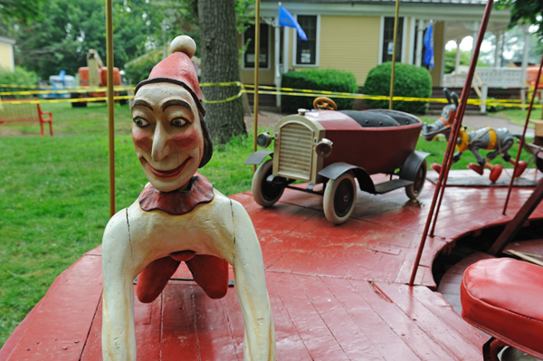 A children's carousel at Fete Paradiso on Governors Island this summer has figures of Punch, automobiles, airplanes and cartoon characters. (Photo: Terese Loeb Kreuzer)