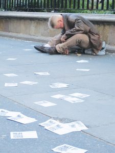 Photo by Lincoln Anderson A heroin user nodded out on Union Square West last year amid fliers promoting an Occupy Wall Street “wildcat march” on May Day that had rained down from a nearby rooftop.