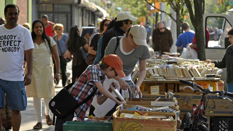 Jackson Heights 24 Marcia Lobas, 43, and Elijah Warrington, 8, check out a book fair on 37th Avenue. (June 15, 2013)