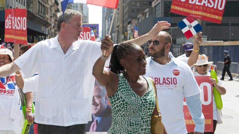 Democratic mayoral candidate Bill de Blasio marches in the Dominican Day Parade on Aug. 11, 2013 with his wife, Chirlane McCray.