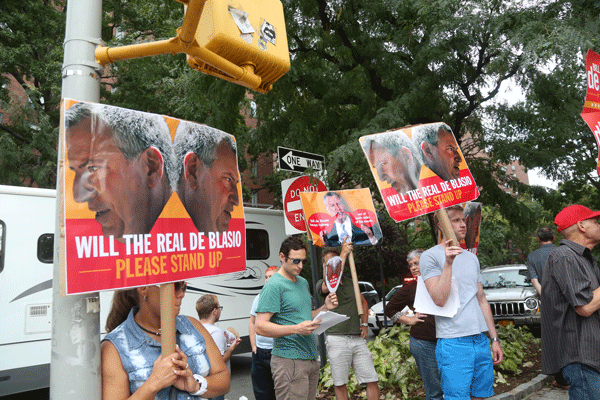 Christine Quinn supporters made their presence known at a Bill de Blasio stop at Stuyvesant Town on Saturday evening. Charging that de Blasio “talks out of both sides of his mouth,” they handed out fliers with a quote from an article in Capital New York, saying how the public advocate has been a “pragmatic deal-maker who chose his battles carefully on the issue of development, rather than that of the populist hardliner he now sounds like.” Photo by Jefferson Siegel