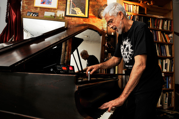 Photo by Bob Krasner Ray Santiago with the 1901 Knabe grand piano he is lovingly restoring.