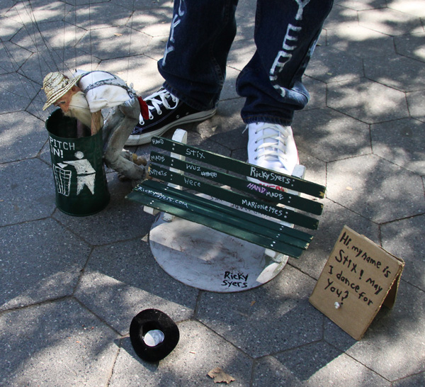 Photos by Tequila Minsky Top, Little Doris feeds a peanut to a squirrel in Washington Square Park. Meanwhile, above, Stix takes a swig of his moonshine — O.K., so he hit himself in the eye, he’s a marionette — and then rummages around in a trash can.