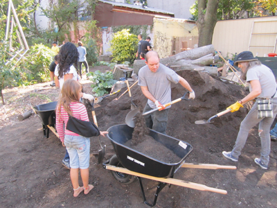 Bill LoSasso and Carolyn Ratcliffe scooped fresh soil into a wheelbarrow so it could be spread out around La Plaza Cultural on Saturday. PHOTO BY LINCOLN ANDERSON