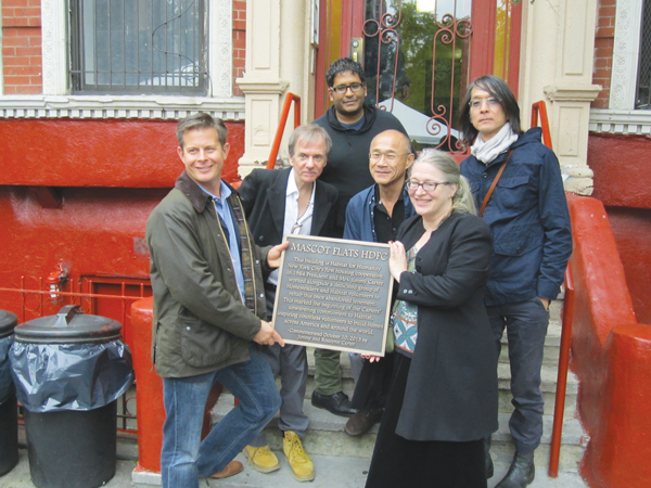 Mascot Flats tenants accepted a plaque from Habitat for Humanity commemorating the renovation project 30 years ago. At right in front row is Ann Rupel and in the middle row center is Don Kao, both original homesteaders from when the building was renovated by Habitat for Humanity in 1984.