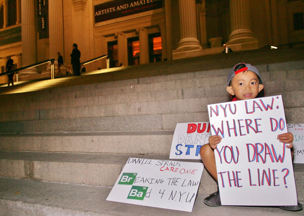 Andre Ucava-Sombillo, grandson of union organizer Isabellita Sombillo, held a protest sign outside the N.Y.U. Law School gala.