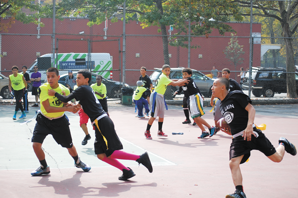 A Black team runner turns the corner and heads upfield behind strong blocking by his teammates.   PHOTO BY DANIEL JEAN-LOUBIN