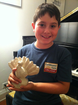 Asher Weintraub, 9, with his invention, the Menurkey, a ceramic turkey menorah. For each of the eight nights of Hannukah, another candle is added to a feather.