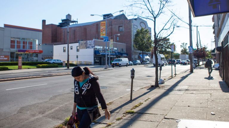 A woman walks down Jamaica Ave. in Queens Village.