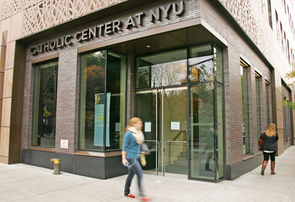 Two young women, one of them sporting awareness-dulling ear buds, walking by the N.Y.U. Catholic Center this Tuesday.  Photo by Sam Spokony