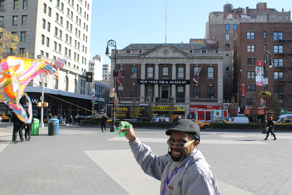 Kevin “The Kite Man” was doing his thing in Union Square’s northern plaza on a windy Tuesday morning, with the recently landmarked former Tammany Hall in the background.  Photo by Lincoln Anderson
