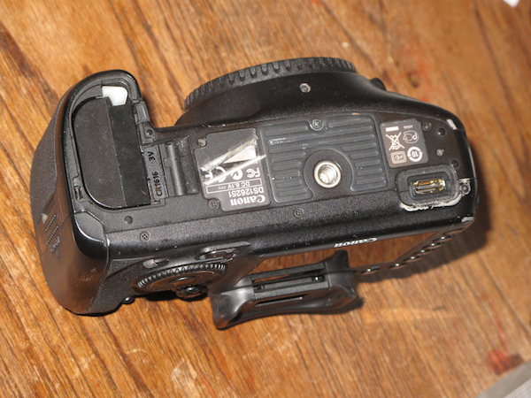 The 7D camera sent back from the Canon repair center — with the battery door still off. 