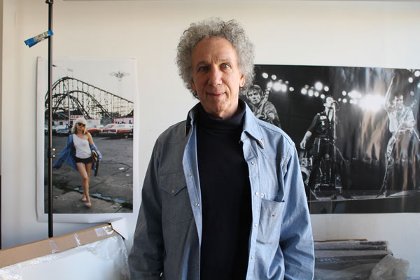 Bob Gruen in his Westbeth studio in front of his photos of Deborah Harry of Blondie, left, during the shooting in Coney Island for the “Mutant Monster Beach Party” fumetti (a comic strip of artfully altered photos by Punk magazine), and The Clash playing in Boston, right. Photo by LINCOLN ANDERSON