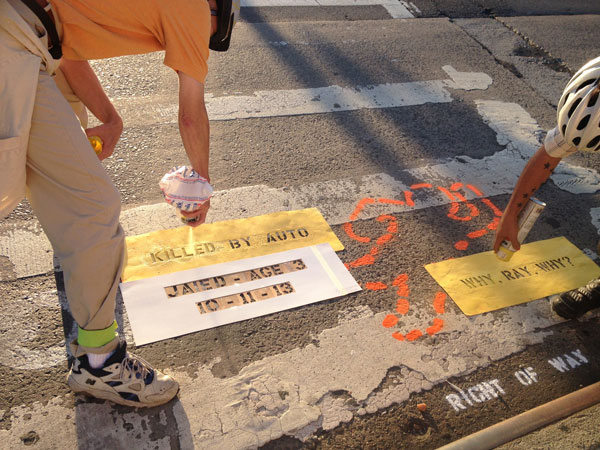 Right of Way members stenciling at the scene of a child fatality during their recent “8 Under 8” action. The activists biked more than 50 miles, to eight sites where young children — all under 8 years old — have been killed by automobiles in New York City this year, painting a stencil at each fatal crash site. They say the Police Department must increase enforcement and investigations for traffic violations and serious accidents.    PHOTO COURTESY RIGHT OF WAY