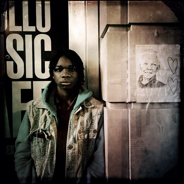 On Thurs., Dec. 5., the day Nelson Mandela died at age 95, Carvel, 14, posed next to a drawing of the great South African freedom fighter and leader outside Harlem’s Apollo Theater. Carvel said, due to his age, he didn’t know much about Mandela, but that he was a great person. Photo by Q. Sakamaki