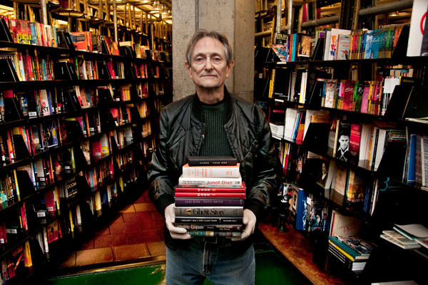St. Mark’s Bookshop co-owner Terry McCoy, wearing protective gloves, holds several of the books to be auctioned this Thursday. Art Spiegelman’s “Maus” has the highest reserve — the starting price below which bids won’t be accepted.   Photo by Bob krasner
