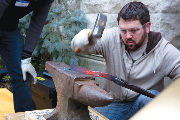 Mike Martin fashioning a piece of a Remington rifle into a mattock, a farming tool, at Middle Collegiate Church on Sunday.  Photo by Béatrice de Géa