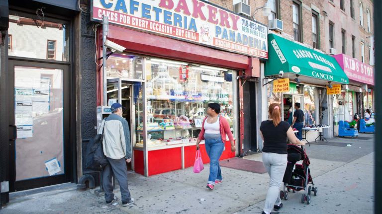 New Yorkers walk along 5th Avenue in front of La Gran Via Bakery. 