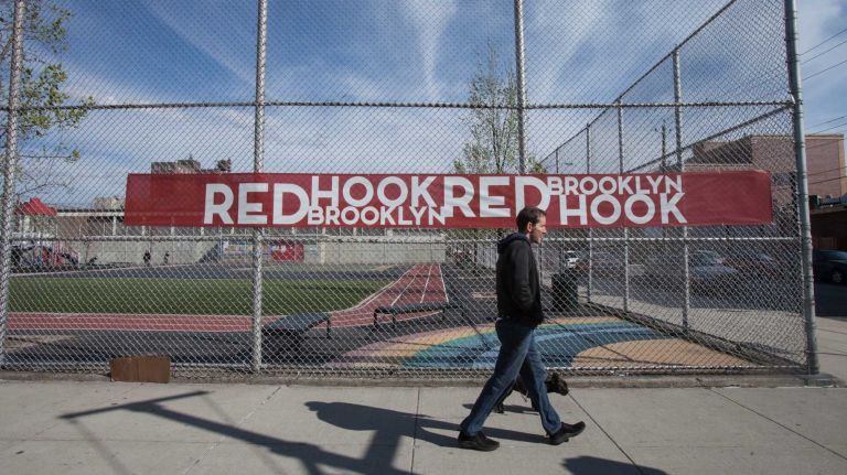 A man walks a dog down Van Brunt Street in Red Hook. (Apr. 20, 2013)