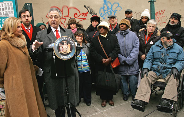 Assembly Speaker Sheldon Silver (at podium), along with Congressmember Carolyn Maloney and state Senator Daniel Squadron (standing to the left of Silver), urged the M.T.A. to finally finish its work on the East Broadway subway escalator.  Photo by Sam Spokony