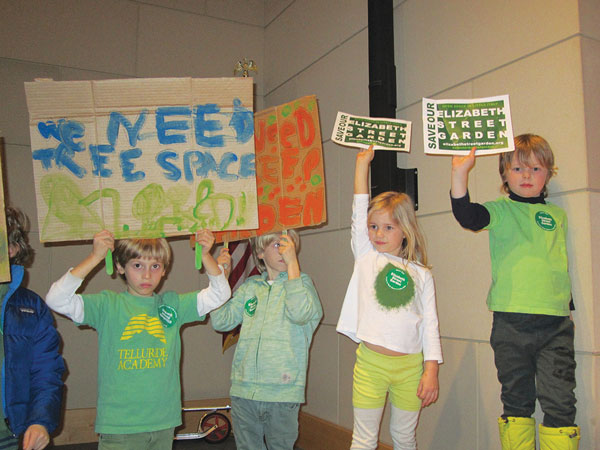 Young Elizabeth St. Garden activists made their point clear at the November 2013 C.B. 2 meeting, hoisting their signs up in the front of the auditorium, right next to where the community board officers were seated on stage.  C.B. voted overwhelmingly to preserve the garden in perpetuity. Photo by Lincoln Anderson